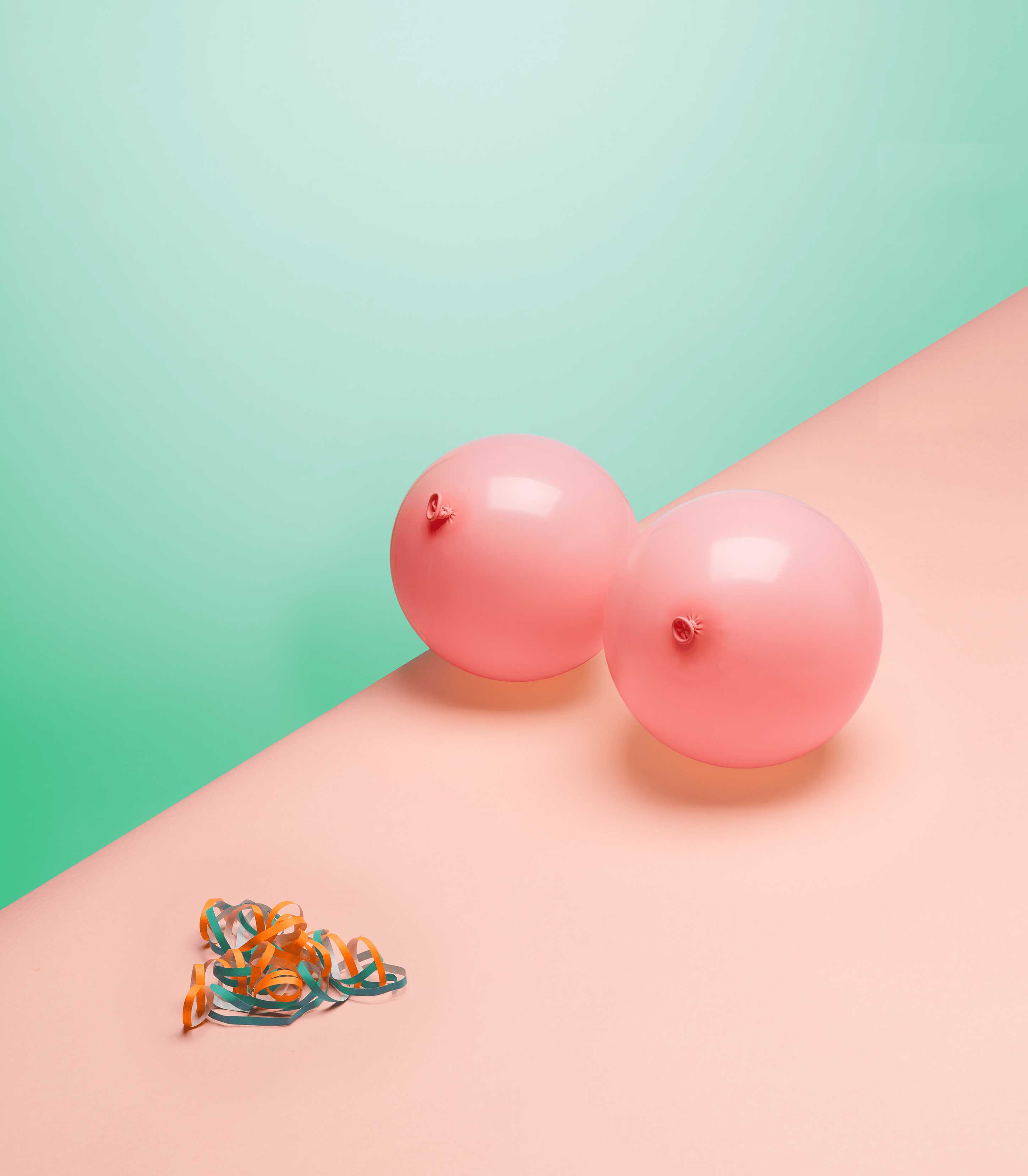 Zwei rosa Luftballons auf pastellfarbenem Untergrund